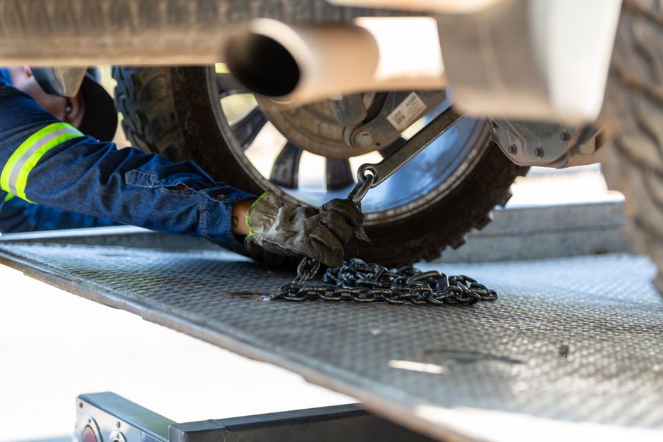 Mechanic securing a vehicle on a service platform with a chain for safe towing. - Photo by Jonathan Reynaga on Pexels